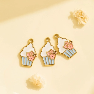 Macro detail of cupcake enamel charms in gold and blue for DIY jewelry making