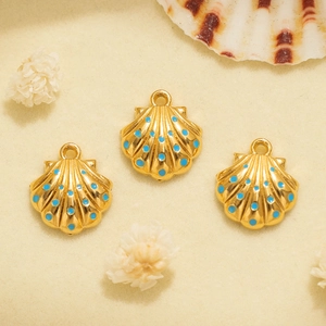 Detalle de tres colgantes de concha dorada con esmalte azul para hacer joyas DIY a mano