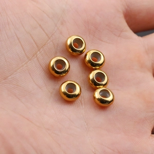 Dettaglio di sei perle distanziatrici in acciaio inossidabile dorato con fodera in silicone