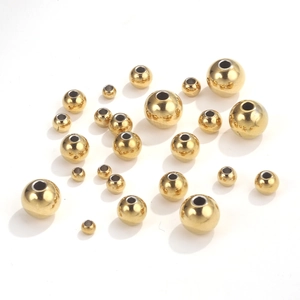 Makroaufnahme polierter goldener Edelstahlperlen mit Löchern für DIY Schmuck