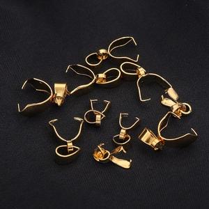 Golden stainless steel bail clasps for DIY jewelry necklaces on dark textured background