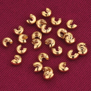 18K gold plated C-shaped crimp bead covers for DIY jewelry making on red fabric