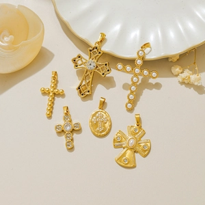 Colgantes de cruz dorados vintage con perlas y pedrería sobre fondo crema elegante