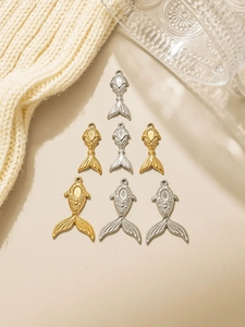 Detailed close-up of golden and silver fish pendants with embossed patterns