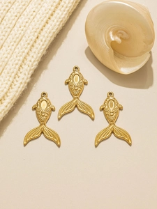 Three golden mermaid tail fish pendants on beige background with a seashell accent