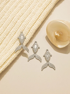Detailed silver mermaid fish pendants with embossed scales on textured knit background