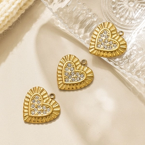 Tres colgantes de corazón dorados con cristales brillantes y bordes con textura fina