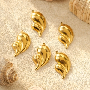 Golden 304 stainless steel swirl pendants for DIY jewelry sets on warm textured background