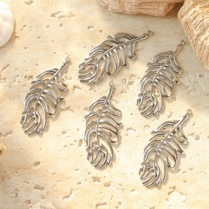 Five hollow feather stainless steel pendants for DIY jewelry set on a natural stone base