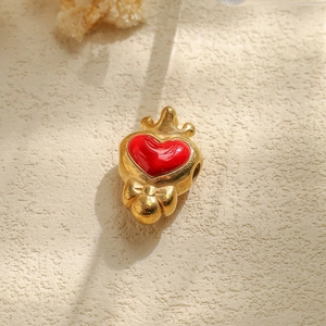 Detailed view of red heart pendant with crown on textured stone background