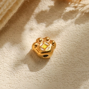 Vue macro d'une perle patte de chat dorée avec motif de pièce pour bijoux DIY