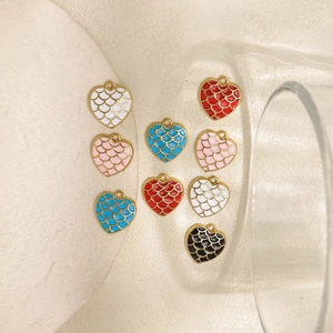 Detailed view of heart-shaped enamel charms with fish scale texture in multiple colors
