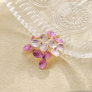 Macro shot of 304 stainless steel flower pendant with purple enamel and gold beads