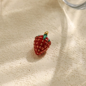 Detailansicht eines roten Emaille-Erdbeeranhängers mit goldenen Samen für DIY-Schmuck