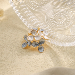 Close-up of blue and white enamel flower pendant with gold plated stainless steel edges