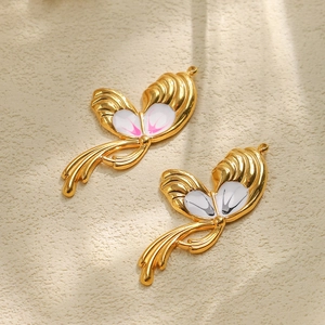 Macro view of gold 304 stainless steel butterfly pendants with white enamel details