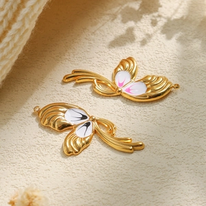 Golden stainless steel butterfly wing pendants with colorful enamel in a lifestyle setting