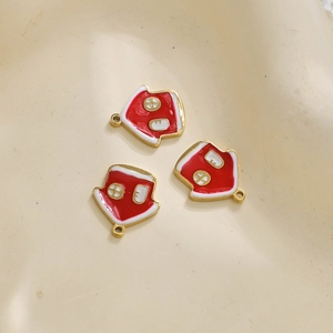 Detailweergave van drie rode emaille huisvormige hangers met gouden randen voor DIY-sieraden