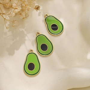 Detail van drie avocado bedeltjes van 304 roestvrij staal op een keramisch oppervlak
