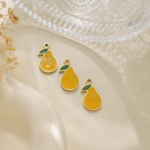Detailed close-up of three yellow pear fruit pendants with gold edges and green leaves