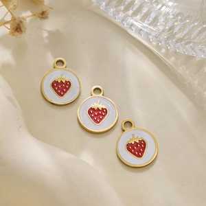Detail of round 304 stainless steel strawberry pendants with red enamel and gold finish