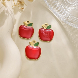 Detail view of three red enamel apple charms for DIY jewelry making and crafting projects