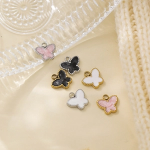 Detail von bunten Emaille-Schmetterlingsanhängern in Gold und Silber für DIY-Halsketten