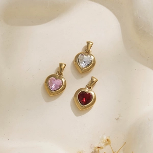 Detalle de colgantes de corazón en rosa, blanco y rojo vino chapados en oro