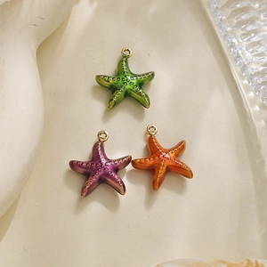 Macro detail of colorful starfish pendants in green, purple and orange with gold rings