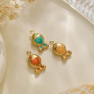Macro detail of gold-plated fish charms with colorful enamel for jewelry making