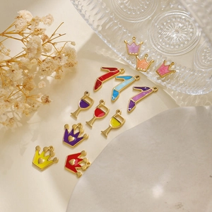 Detailopname van kleurrijke emaille bedeltjes met kroon en naaldhak voor DIY-sieraden