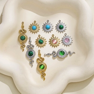 Goldene und silberne Schlangen- und Sonnenanhänger mit Türkis und Opal auf einem Tablett