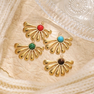 Detail view of 304 stainless steel leaf pendants with turquoise insets on textured gold finish