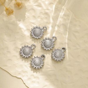 Detailed view of 5 small sunflower pendants for jewelry making on textured paper