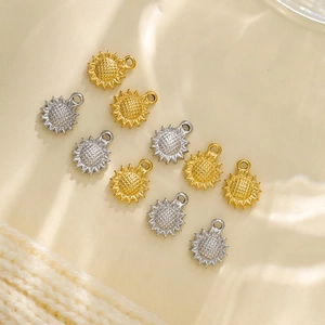Macro detail of gold and silver sunflower charms with textured petals for DIY jewelry