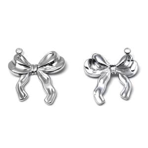 Detailed macro view of polished 304 stainless steel bow pendant charms for jewelry making