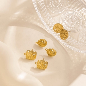 Macro shot of gold hammered metal flower and geometric DIY earring findings on cloth