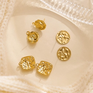 Macro detail of three gold geometric stainless steel DIY earring studs with hammered texture