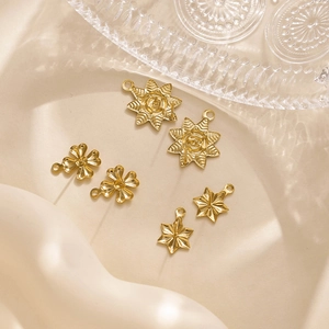 Macro detail of gold stainless steel sunflower, clover and star jewelry pendants