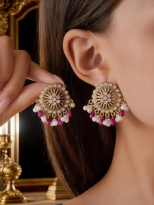 Close-up of Bohemian flower earrings with white pearls and pink beads on a model