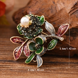 Vintage enamel peony brooch with white pearl and rhinestones on retro wood background