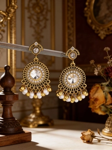 Macro detail of bohemian vintage gold earrings with zircon crystals and pearl tassels