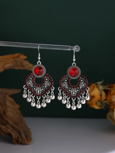 Detail of bohemian silver alloy earrings with red crystals and metallic bead tassels