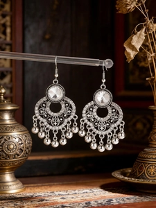 Close-up of bohemian silver drop earrings with faceted crystals and hanging beads