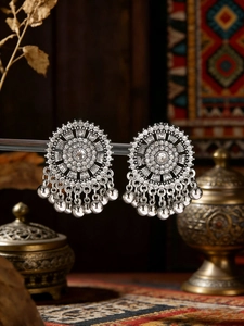 Detailed macro view of vintage silver mandala earrings with bead drops and rhinestones