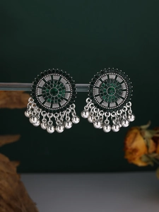 Detailed view of silver bohemian round earrings with green stones and fringe pendants