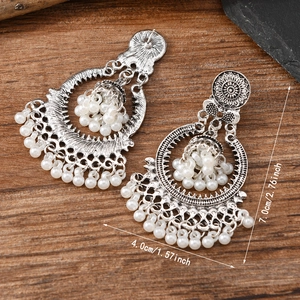 Detailed view of silver ethnic earrings with white pearls and size measurements