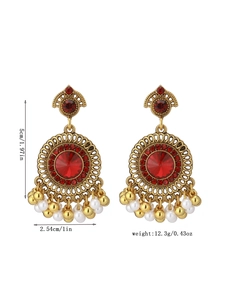 Detail view of retro red crystal earrings with gold beads and white faux pearls
