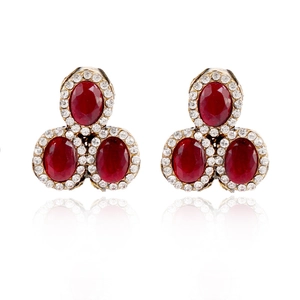Close-up of vintage ruby earrings with three oval gems and sparkling crystal accents