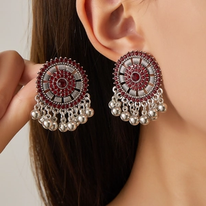 Bohemian silver hoop earrings with red rhinestones and metal bead tassels on model